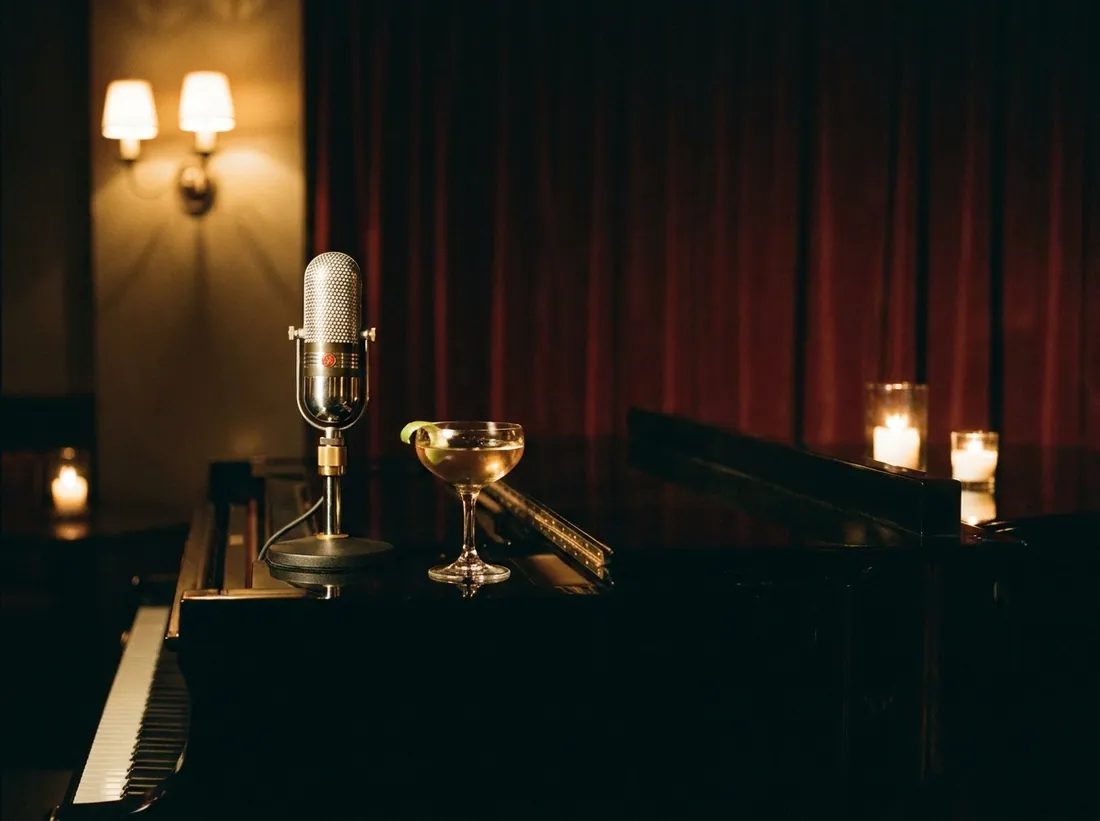A vintage microphone resting on a grand piano